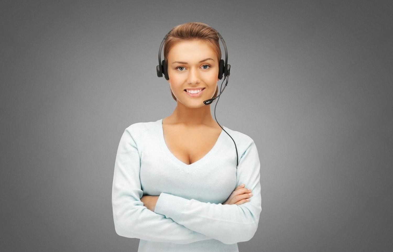 Friendly female IT helpdesk agent with headset ready to assist a Dubai office